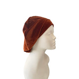 Brown velvet headscarf on a mannequin head against a white background