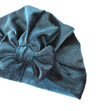 Blue glittery headband with a large bow on a white background