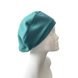 Teal beanie on a mannequin head against a white background
