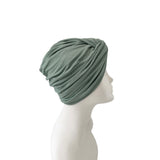 Green headscarf on a mannequin head against a white background