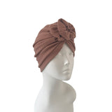 Brown turban on a mannequin head against a white background