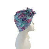 Colorful shell-patterned headscarf on a mannequin head against a white background