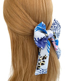 Blue and white patterned hair scrunchie on a ponytail against a white background