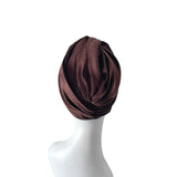 Brown headscarf on a white mannequin head against a white background