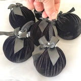 Black velvet ornaments with ribbons on a white background
