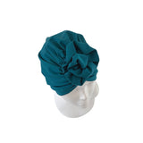 Teal headscarf on a mannequin head against a white background