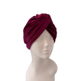 Magenta turban on a mannequin head against a white background