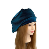 Blue turban on a mannequin head with long brown hair against a white background