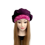 Mannequin head with a purple and pink headscarf on a white background