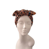 A leopard print fabric headwrap styled on a mannequin head against a plain white background.