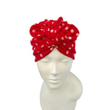 Red headband with white polka dots on a mannequin head against a white background