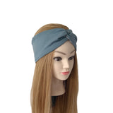 A mannequin head with long light brown hair wearing a slate blue twisted headband, shown against a plain white background.