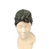 Green textured headscarf on a mannequin head against a white background
