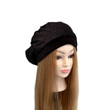 Black turban on a mannequin head with long brown hair against a white background