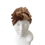 Brown headband on a mannequin head against a white background