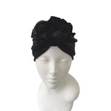 Black turban on a mannequin head against a white background