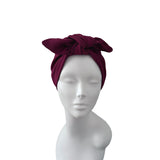 A dark burgundy ribbed fabric headwrap styled on a white mannequin head against a plain white background.