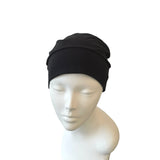 Black beanie on a mannequin head against a white background