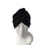 Black knit turban on a mannequin head against a white background