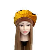 Mannequin head with a yellow and brown hat on a white background