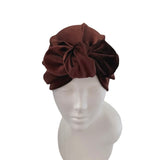 Brown headband with a large bow on a mannequin head against a white background