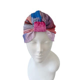 Colorful striped headscarf on a mannequin head against a white background