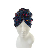 Navy blue headscarf with colorful patterns on a mannequin head against a white background
