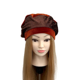 Mannequin head with a brown and orange hat on a white background