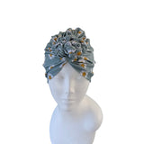 Gray headscarf with floral pattern on a mannequin head against a white background