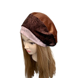 Mannequin head with a brown and pink headscarf on a white background