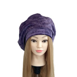 Purple towel on a mannequin head with a white background
