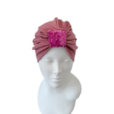 Pink headband with a textured square on a mannequin head against a white background