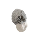 Gray headscarf with a flower on a mannequin head against a white background