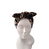 A leopard print velvet headwrap styled on a white mannequin head against a plain white background.