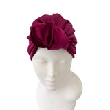 Maroon headscarf on a mannequin head against a white background