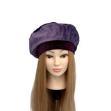 Purple beret on a mannequin head with long hair against a white background