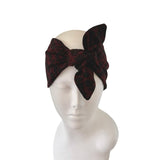 Brown headband with a large bow on a mannequin head against a white background