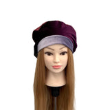 Mannequin head with a purple and black hat on a white background