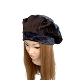 Black velvet head wrap on a mannequin head with brown hair against a white background