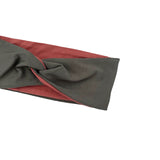 A close-up of a fabric headwrap or scarf with a twisted knot detail, featuring a dark gray outer layer and a rust red inner lining, shown against a plain white background.