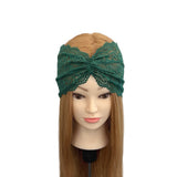 Green lace headband on a mannequin head with long brown hair against a white background