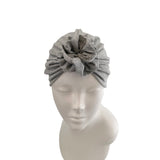 Gray headscarf with a flower on a mannequin head against a white background