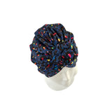 Navy blue headscarf with colorful patterns on a mannequin head against a white background