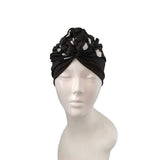 Black headscarf with floral design on a mannequin head against a white background