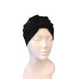 Black turban with sequins on a mannequin head against a white background