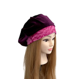 Mannequin head wearing a purple and pink headscarf on a white background