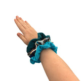 Hand wearing a blue scrunchie on a white background