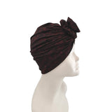 Dark red headband with a bow on a mannequin head against a white background