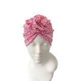 Pink patterned headscarf on a mannequin head against a white background