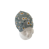 Gray headscarf with floral pattern on a mannequin head against a white background